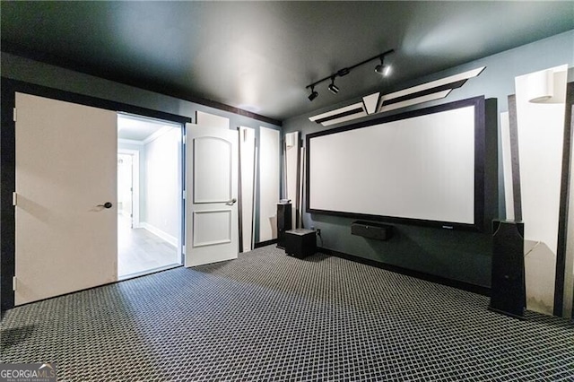 carpeted cinema room featuring crown molding and rail lighting