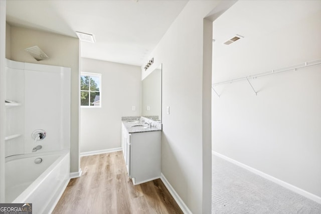 bathroom with vanity,  shower combination, and hardwood / wood-style flooring