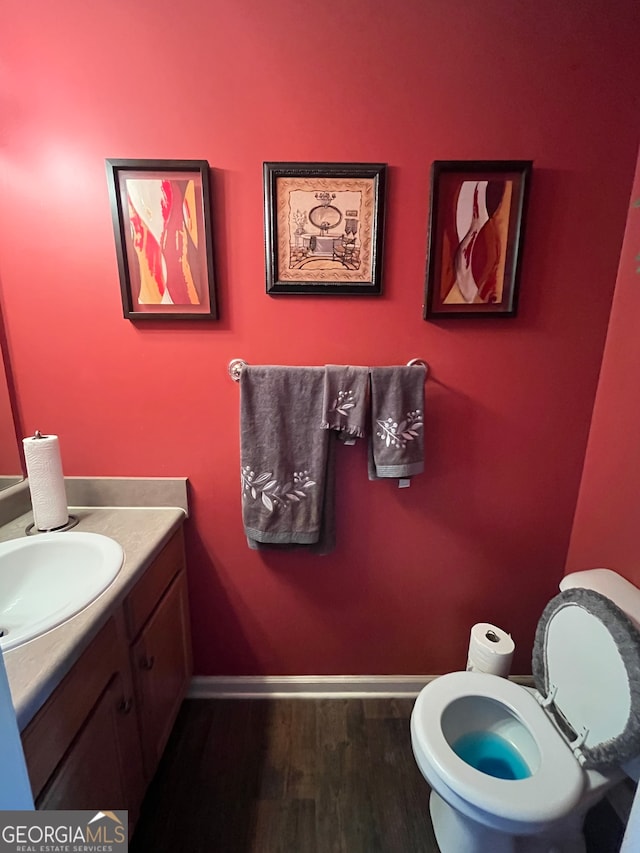 bathroom featuring vanity, toilet, and hardwood / wood-style flooring