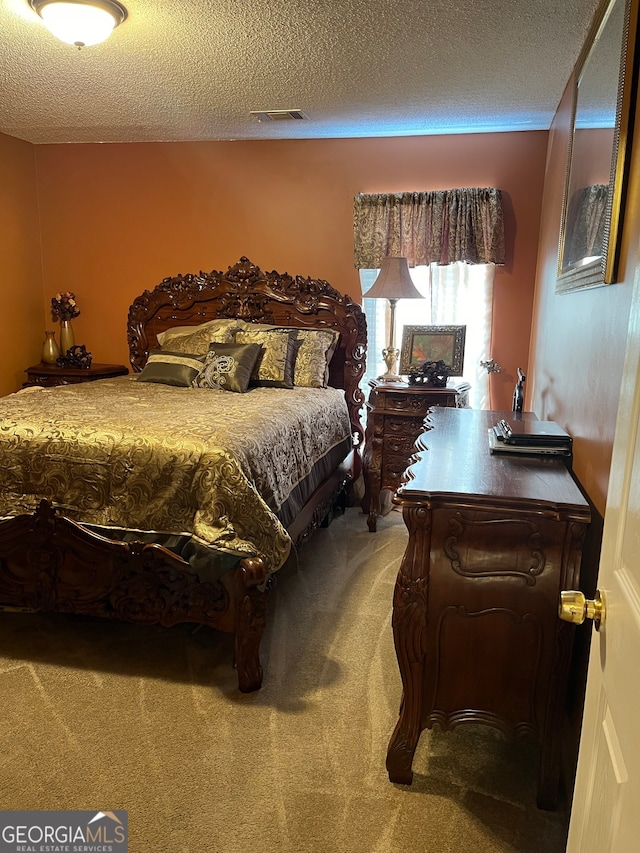 bedroom with carpet floors and a textured ceiling