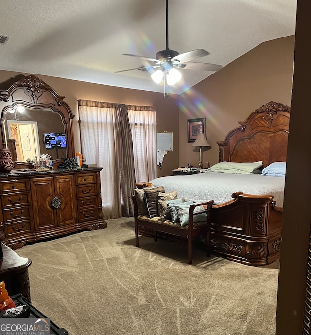 carpeted bedroom with ceiling fan and vaulted ceiling