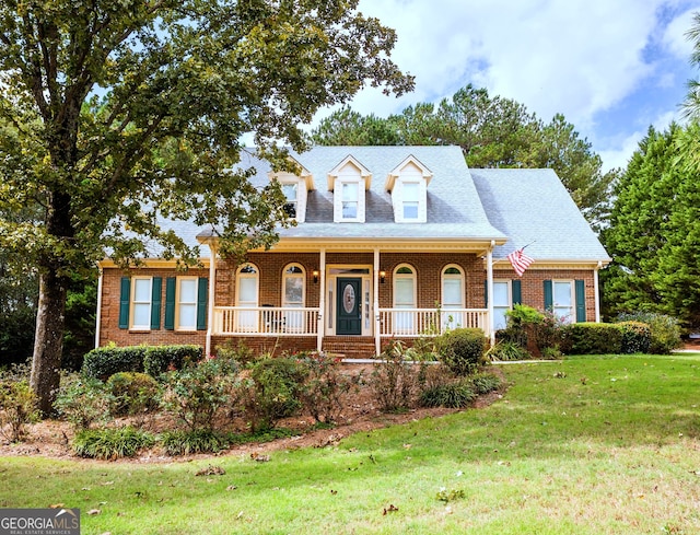 cape cod-style house featuring a front lawn and covered porch