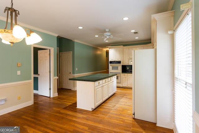 kitchen featuring white appliances, ceiling fan, hardwood / wood-style floors, and crown molding