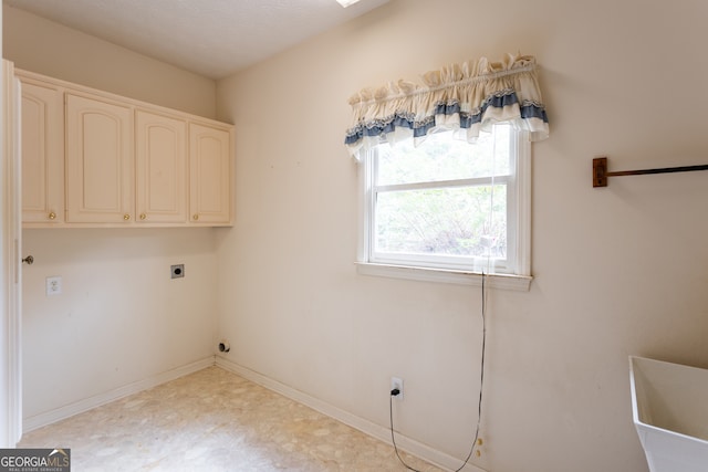 laundry area featuring cabinets, hookup for an electric dryer, and a textured ceiling