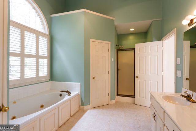 bathroom featuring a healthy amount of sunlight, independent shower and bath, and vanity