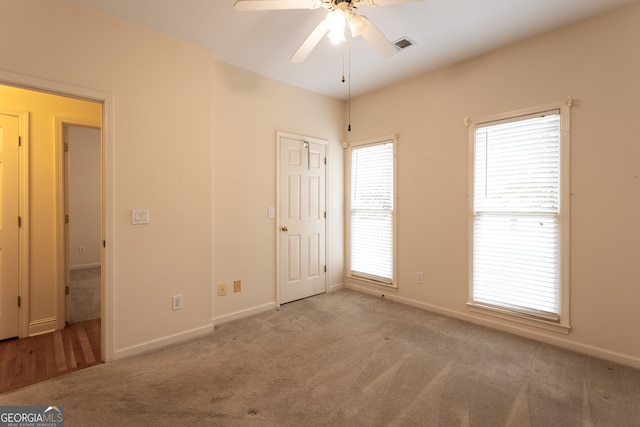 interior space with ceiling fan and light colored carpet