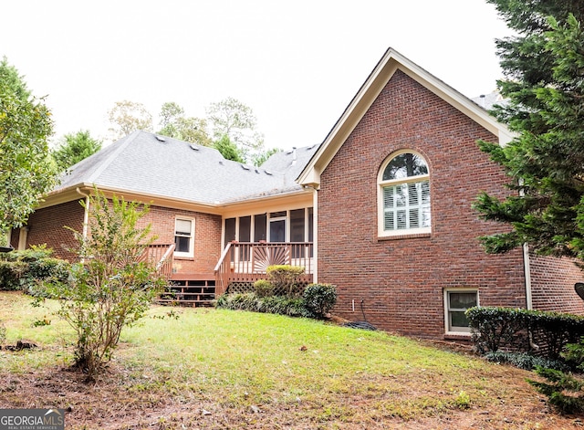 rear view of house with a sunroom and a yard