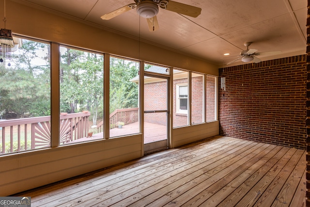 unfurnished sunroom with a wealth of natural light and ceiling fan