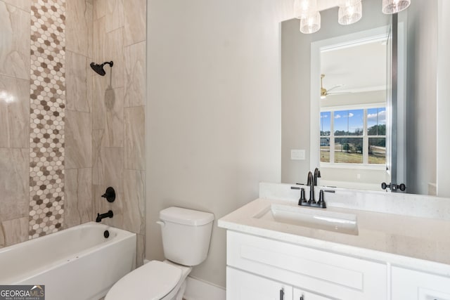 full bathroom with tiled shower / bath combo, vanity, ceiling fan, and toilet