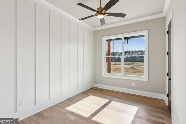 empty room with crown molding, ceiling fan, and light wood-type flooring