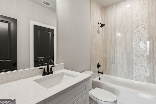 full bathroom featuring vanity, tiled shower / bath combo, and toilet