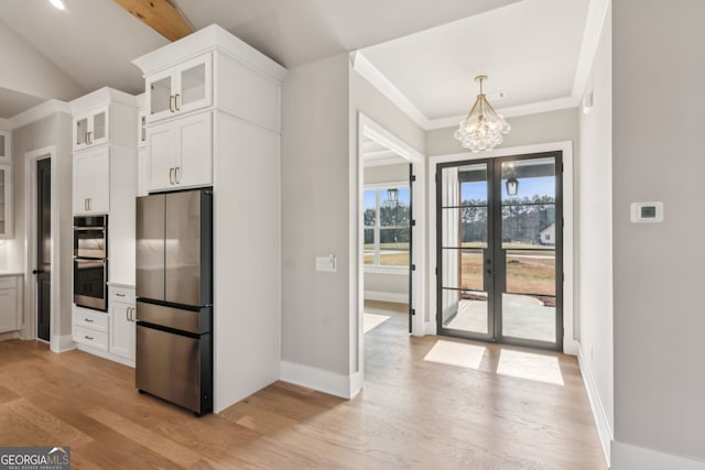 kitchen with an inviting chandelier, stainless steel appliances, light hardwood / wood-style flooring, and white cabinets