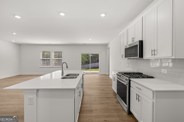 kitchen featuring an island with sink, white cabinetry, appliances with stainless steel finishes, and sink