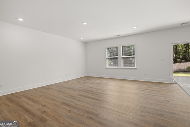 spare room with light hardwood / wood-style floors and a wealth of natural light