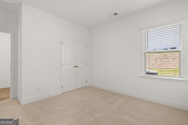 unfurnished bedroom featuring light carpet