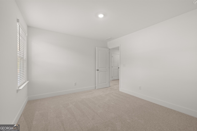 unfurnished room featuring light carpet