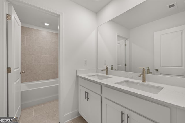 bathroom featuring tile patterned flooring, tiled shower / bath combo, and vanity