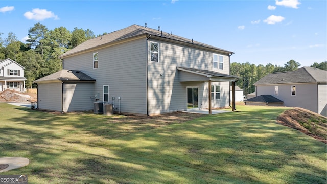 rear view of property featuring a patio, cooling unit, and a yard