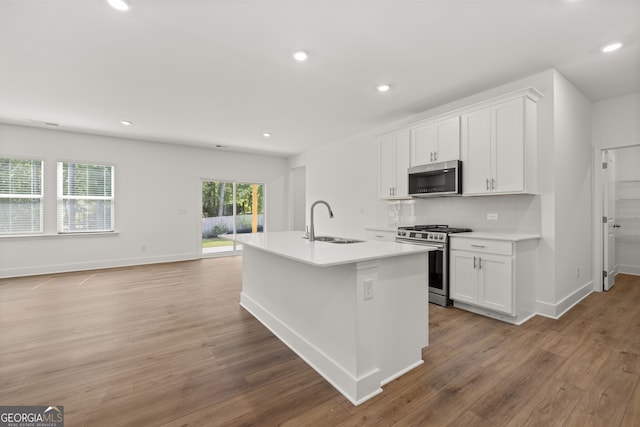 kitchen with an island with sink, white cabinetry, appliances with stainless steel finishes, and sink