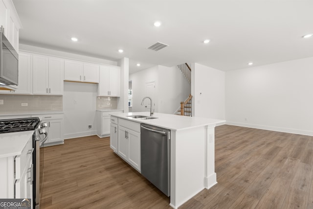 kitchen featuring light hardwood / wood-style floors, an island with sink, appliances with stainless steel finishes, and sink