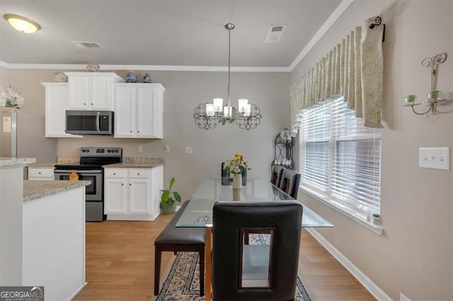 kitchen with hanging light fixtures, light hardwood / wood-style flooring, stainless steel appliances, and white cabinets