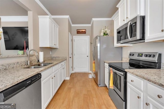 kitchen with stainless steel appliances, white cabinetry, light hardwood / wood-style floors, and sink