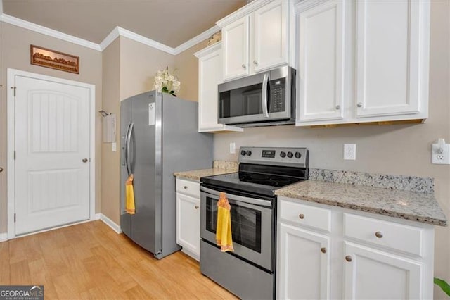 kitchen featuring appliances with stainless steel finishes, white cabinets, light stone countertops, light wood-type flooring, and crown molding