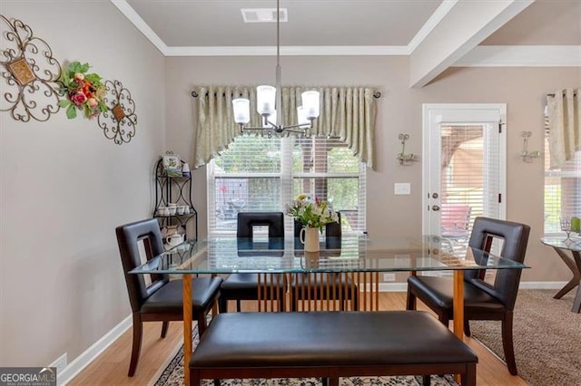 dining area with an inviting chandelier, hardwood / wood-style floors, and a healthy amount of sunlight