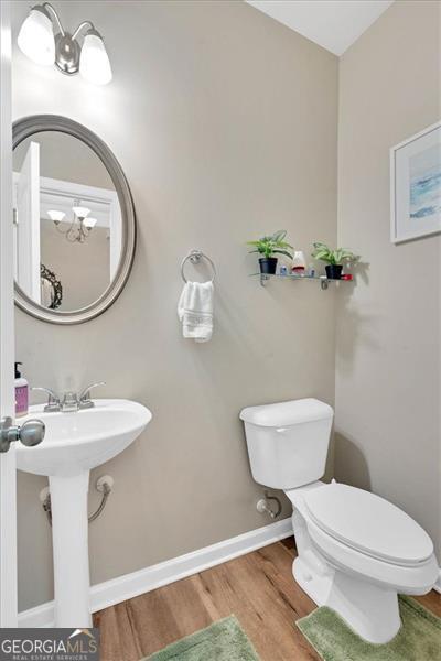 bathroom featuring hardwood / wood-style flooring and toilet