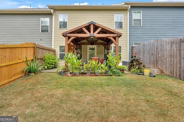 rear view of house with a gazebo and a lawn