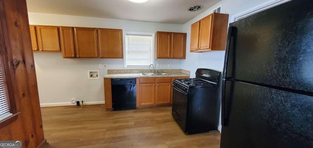 2704 Gresham Rd SE, Atlanta, GA 30316 - kitchen with light wood-type flooring, a sink, brown cabinets, and black appliances
