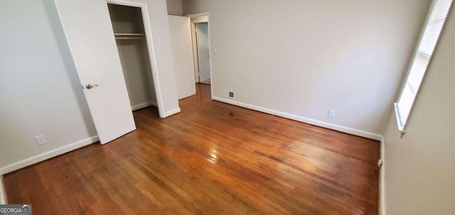 unfurnished bedroom featuring a closet and hardwood / wood-style floors