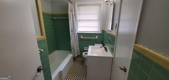 2704 Gresham Rd SE, Atlanta, GA 30316 - full bathroom with tile patterned flooring, toilet, tile walls, a wainscoted wall, and a sink