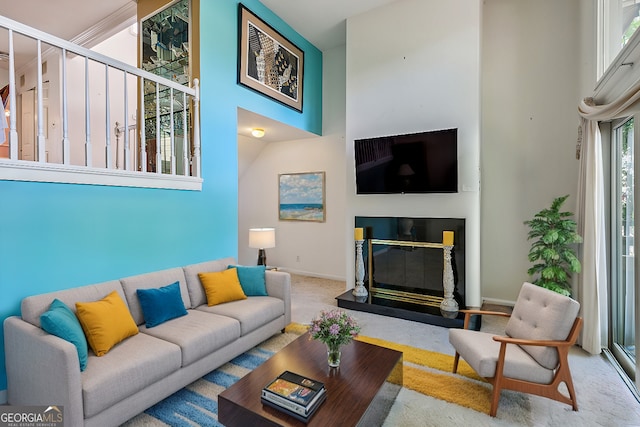 carpeted living room with a high ceiling and a wealth of natural light