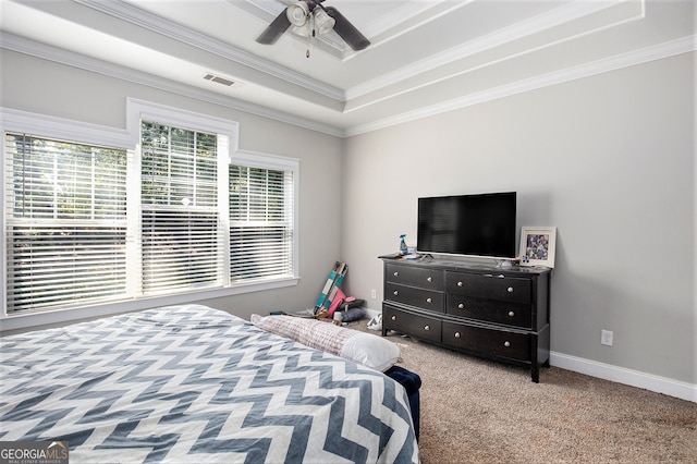 bedroom featuring ceiling fan, a tray ceiling, light carpet, and crown molding