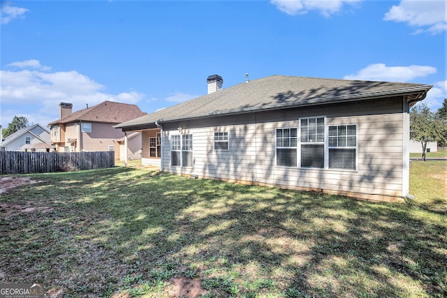 rear view of property featuring a yard