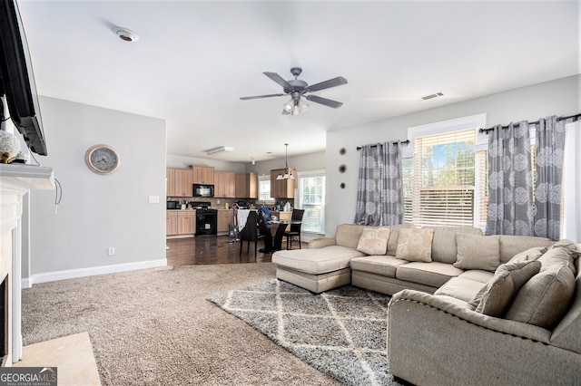 living room with ceiling fan, plenty of natural light, and dark hardwood / wood-style floors