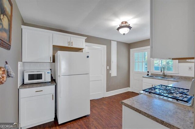 kitchen featuring sink, white appliances, white cabinets, and dark hardwood / wood-style flooring