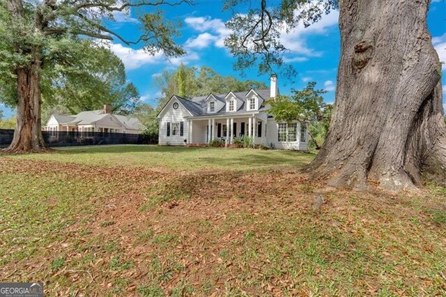 view of front of house with covered porch and a front lawn