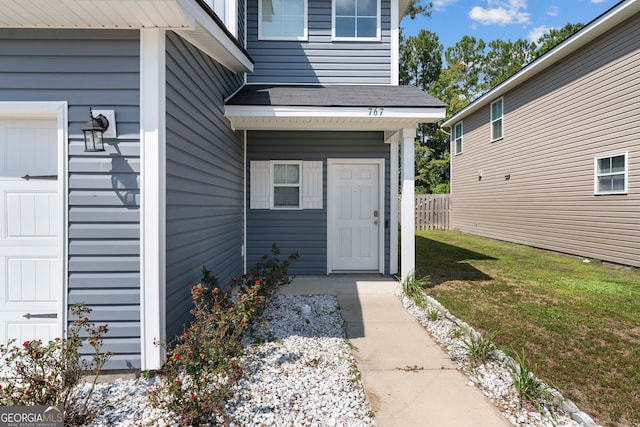 entrance to property featuring a lawn