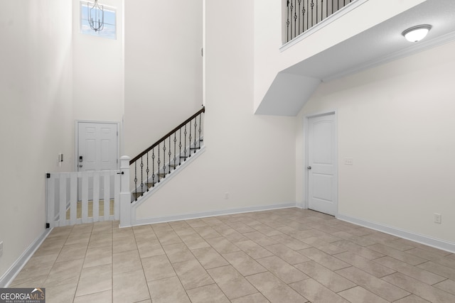 stairs featuring a textured ceiling, crown molding, and a high ceiling