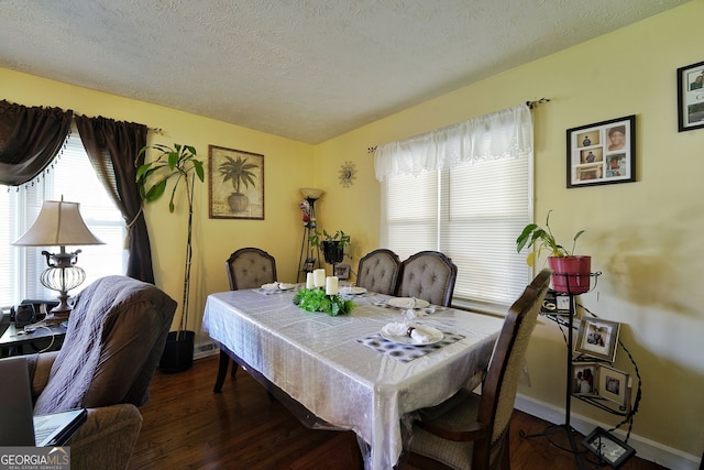 dining area featuring a textured ceiling and dark hardwood / wood-style flooring