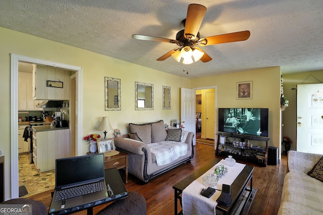 living room featuring a textured ceiling, dark hardwood / wood-style flooring, and ceiling fan