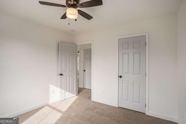 unfurnished bedroom featuring ceiling fan and light colored carpet