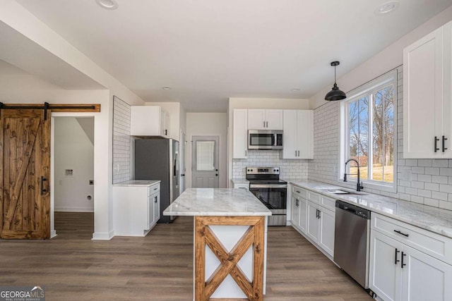 kitchen with hanging light fixtures, sink, dark wood-type flooring, and stainless steel appliances