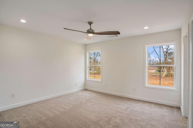 carpeted empty room featuring ceiling fan and plenty of natural light