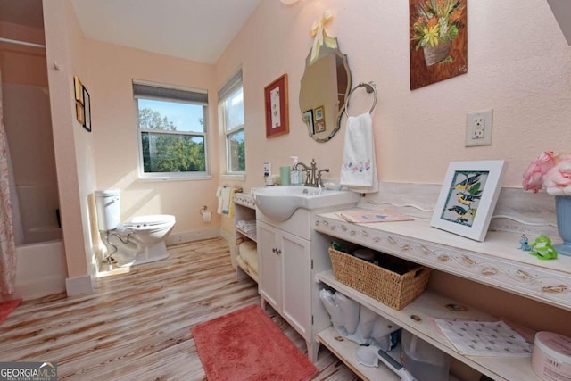 full bathroom featuring hardwood / wood-style floors, vanity, toilet, and shower / bath combination with curtain