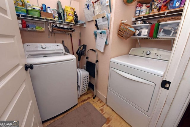 clothes washing area with light hardwood / wood-style floors and washing machine and clothes dryer