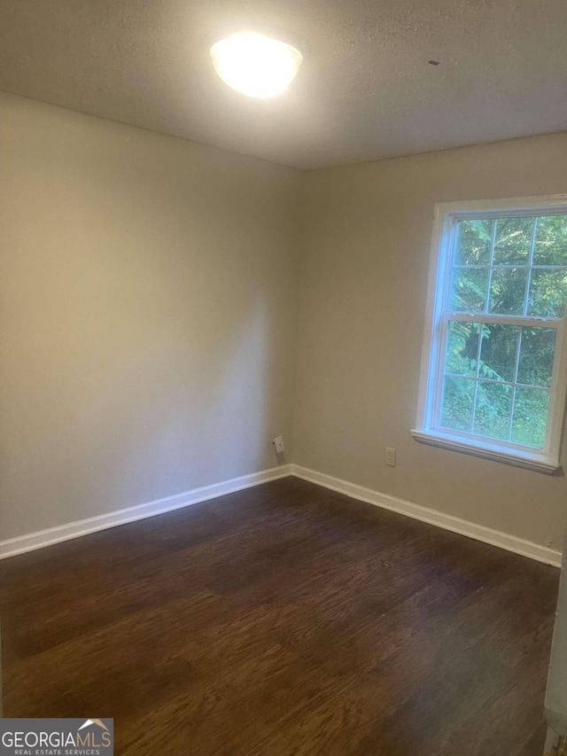 empty room with dark wood-type flooring