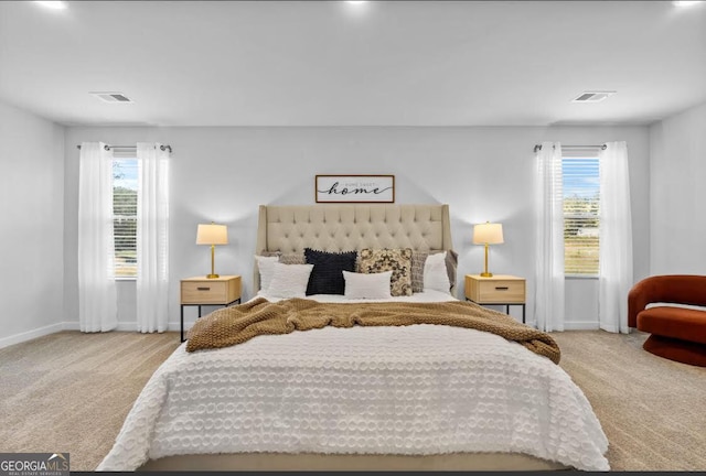 carpeted bedroom featuring visible vents, multiple windows, and baseboards